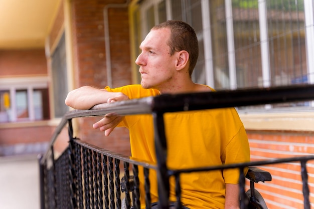 Portrait of serious disabled person in yellow dress in wheelchair at school