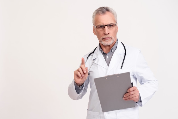 Portrait of serious doctor in white gown with stethoscope