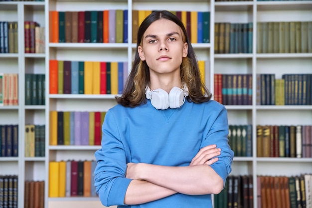 Portrait of serious guy student looking at camera in library