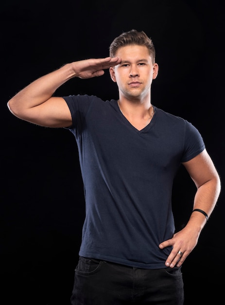 Portrait of serious handsome man posing in studio over black background