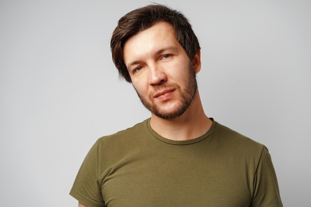 Portrait of a serious pensive young man against grey background