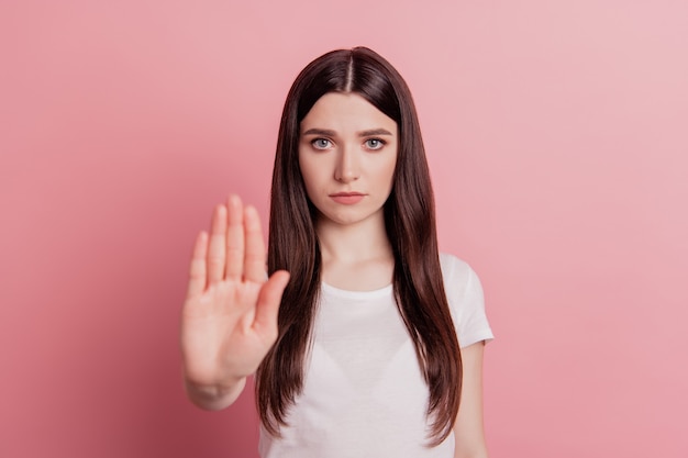 Portrait of serious strict girl show hand no stop sign reject refuse forbidden decline isolated over pastel color background