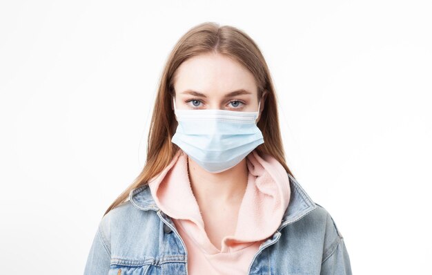 Portrait of serious young woman in medical mask isolated on white background