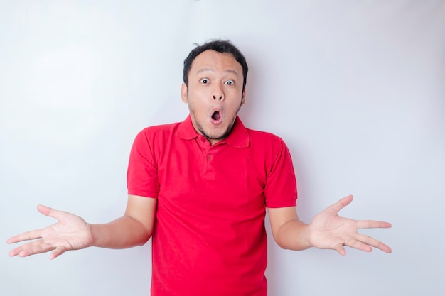 A portrait of a shocked Asian man wearing a red tshirt isolated by a white background