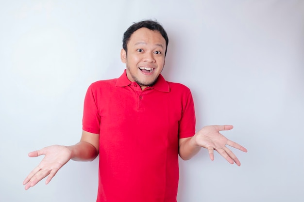 A portrait of a shocked Asian man wearing a red tshirt isolated by a white background