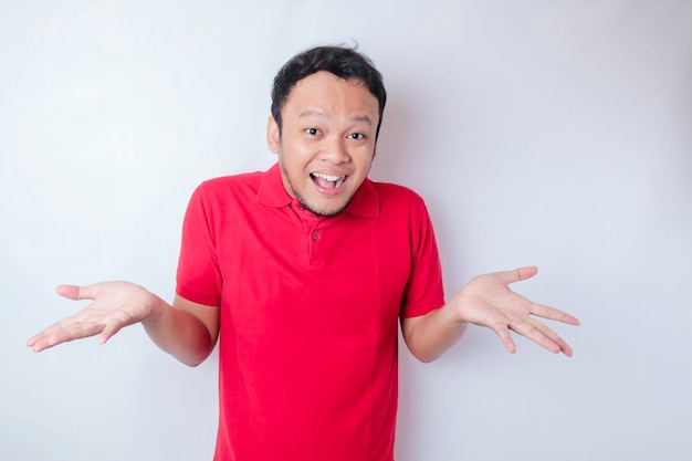 A portrait of a shocked Asian man wearing a red tshirt isolated by a white background