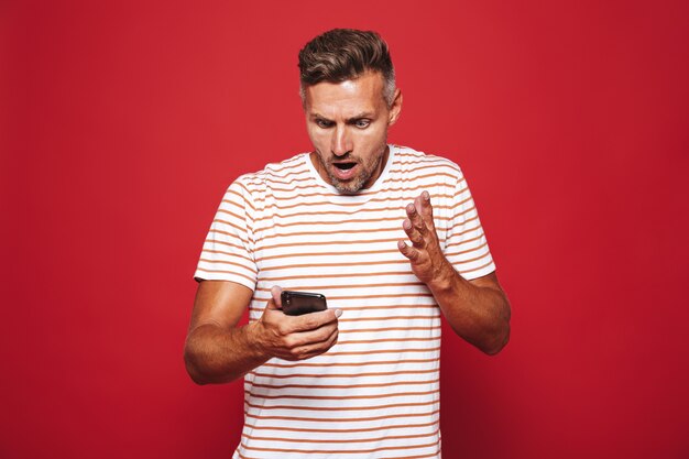 Portrait of a shocked man standing on red