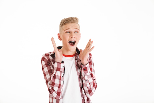 Photo portrait of a shocked schoolboy screaming