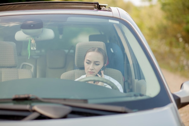 Portrait shot through windshield of pretty woman in car