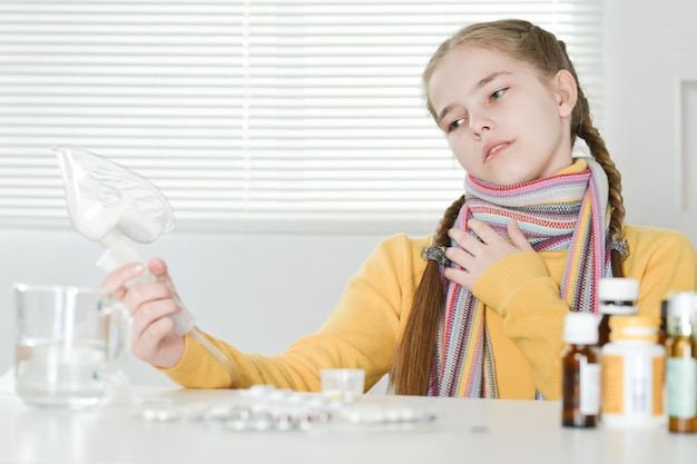 Portrait of a sick girl with inhaler at home