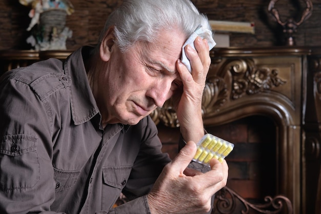 Portrait of sick senior man with pills