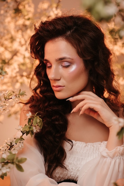 Portrait of a sitting girl, looking like a nymph, in a blooming garden. The concept of fantasy and fairy tales