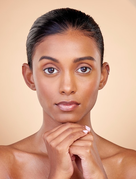 Portrait skincare and woman with self care cosmetics and luxury on a brown studio background Face female person or model with makeup shine and glow with natural beauty dermatology and aesthetic