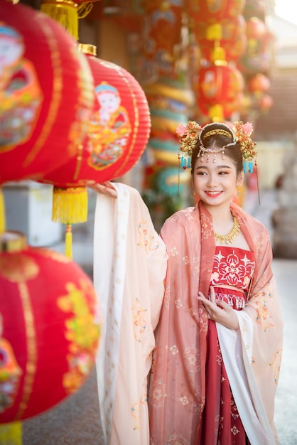 Portrait smile Cute little Asian girl wearing Chinese costumes decoration for Chinese new year festival celebrate culture of china at Chinese shrine Public places in Thailand