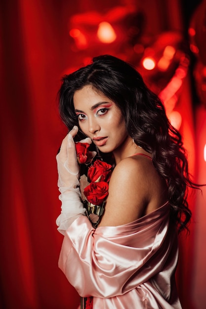 Portrait of smile sexy asian girl glam makeup in lace lingerie and fishnet gloves with red roses