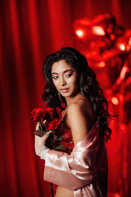 Portrait of smile sexy asian girl glam makeup in lace lingerie and fishnet gloves with red roses