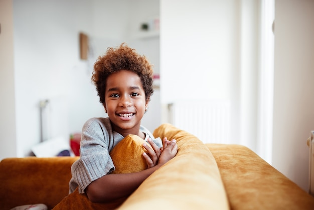 Portrait of smiling african american girl on the sofa.