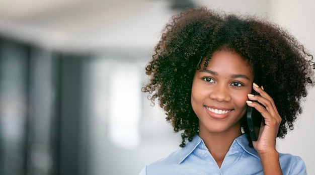 Portrait of smiling african woman talking on mobile phone copy space