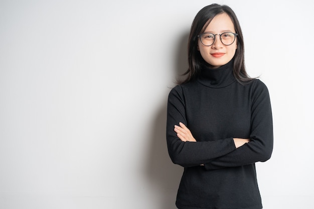 Portrait of a smiling asian businesswoman standing with crossed arms and wearing glasses