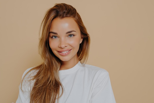 Portrait of smiling beautiful female with long light brown straight hair