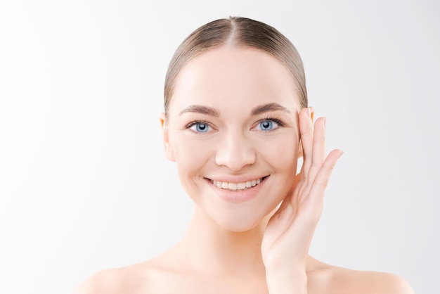 Portrait smiling beautiful young girl with perfect glowing skin and bare