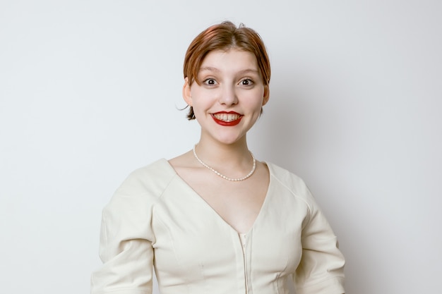 Portrait of a smiling beautiful young girl with red lips and big eyes