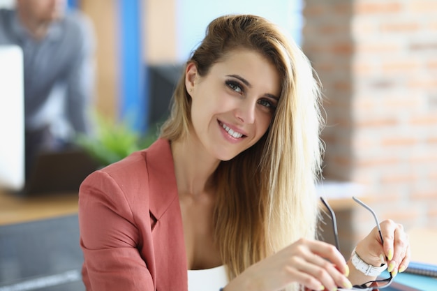 Portrait of smiling blonde businesswoman at workplace