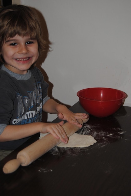 Photo portrait of smiling boy preparing food at home