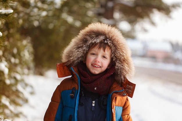 Portrait of smiling boy in a snowy forest in winter