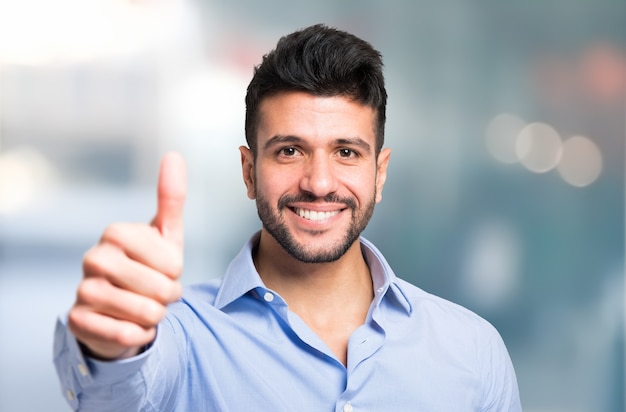 Portrait of a smiling business man giving thumbs up