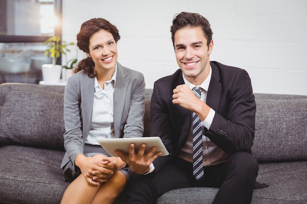 Portrait of smiling business people using digital tablet