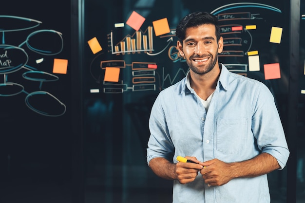 Portrait of smiling businessman standing at glass board with graph Tracery