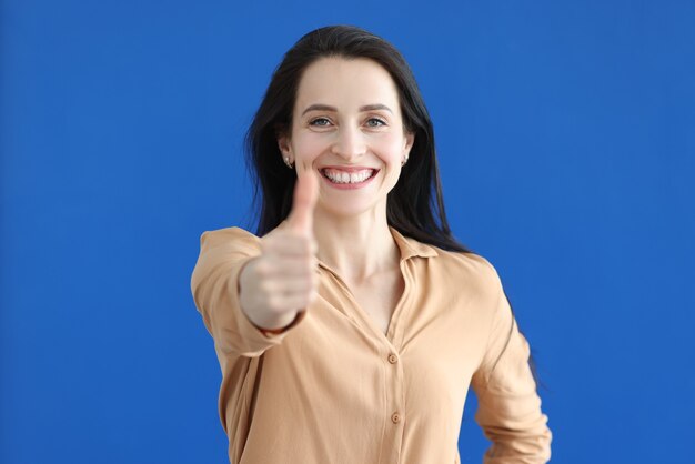 Portrait of smiling businesswoman showing thumbs up gesture