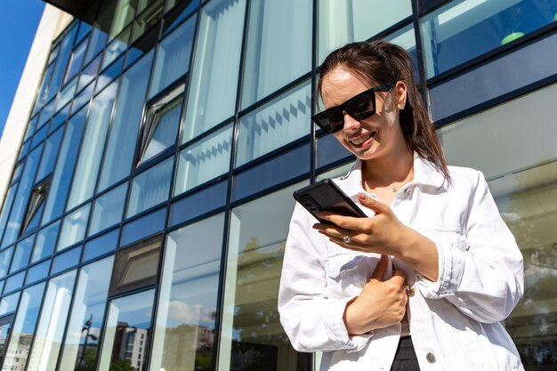 Portrait of smiling caucasian woman with white teeth chatting on phone searching information typin