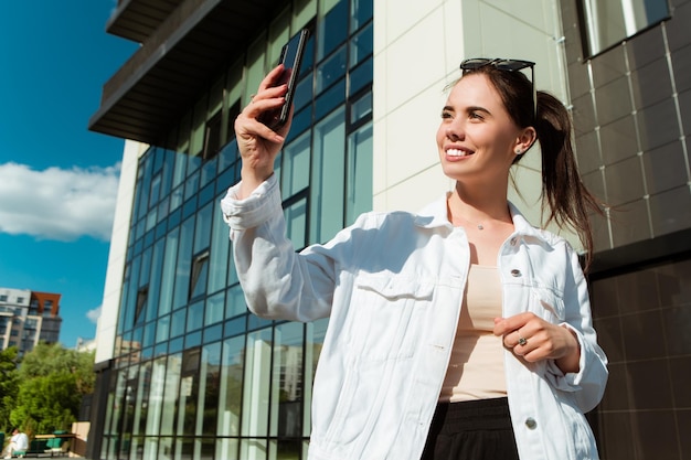 Portrait of smiling caucasian woman with white teeth taking selfie on phone