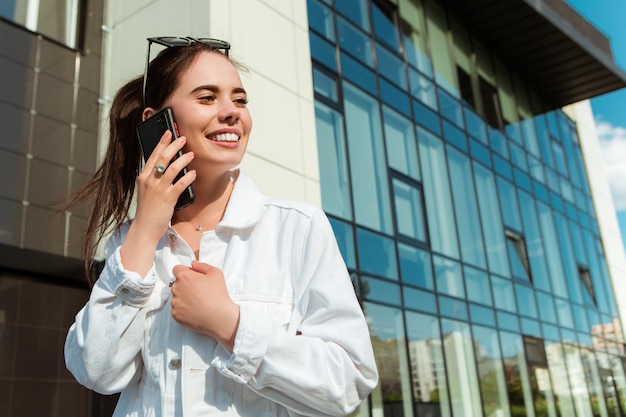 Portrait of smiling caucasian woman with white teeth talking on phone