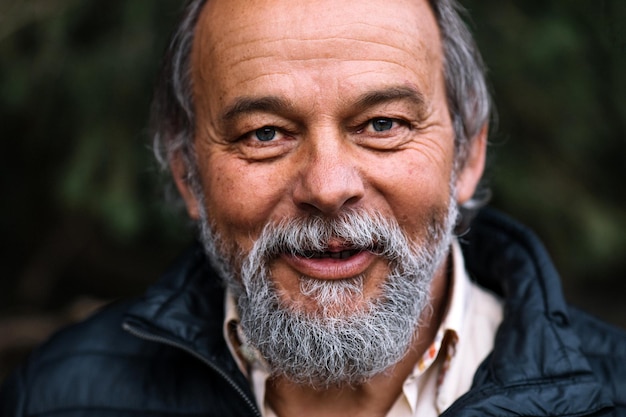 Portrait of a smiling confident handsome mature man during his walk in the park anti ageing