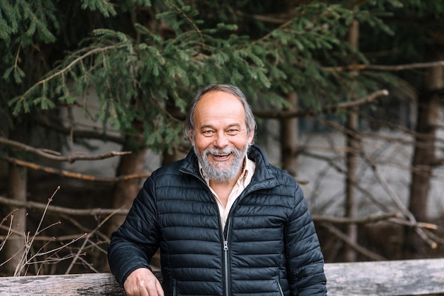 Portrait of a smiling confident handsome mature man looking at the camera during his walk