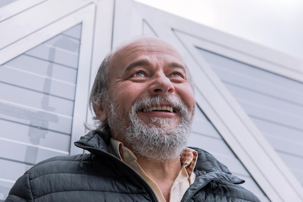 Portrait of a smiling confident handsome mature man near his house