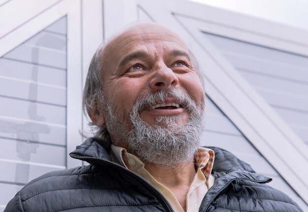 Portrait of a smiling confident handsome mature man senior near his house