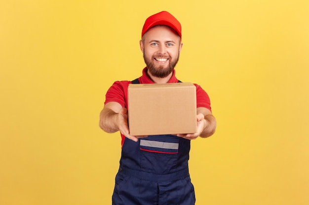 Portrait of smiling courier man holding cardboard parcel delivering order doortodoor