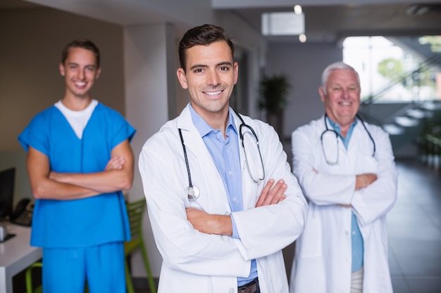 Portrait of smiling doctors standing with arms crossed