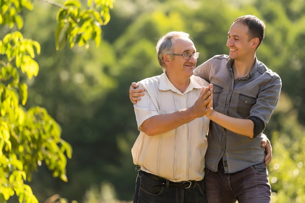 Portrait of a smiling father with adult son at the park