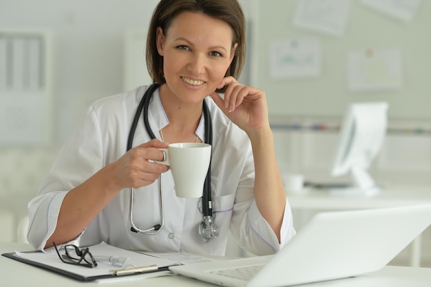 Portrait of smiling female doctor with tea in hospital