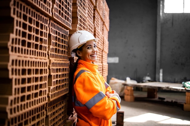 Portrait of smiling female worker standing in factory