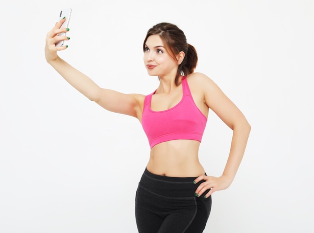 Portrait of a smiling fitness woman with smartphone Selfie time