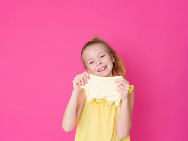 Photo portrait of a smiling girl against pink background