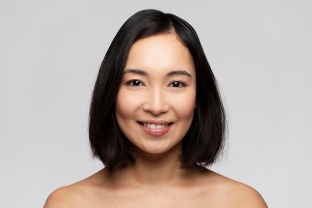 Portrait of smiling girl enjoying beauty treatment on white background