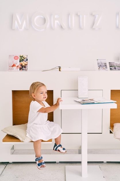 Photo portrait of a smiling girl sitting on table