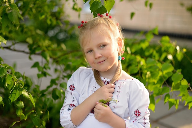 Portrait of a smiling girl with a flower in a Ukrainian embroidered shirt Ukrainian traditions